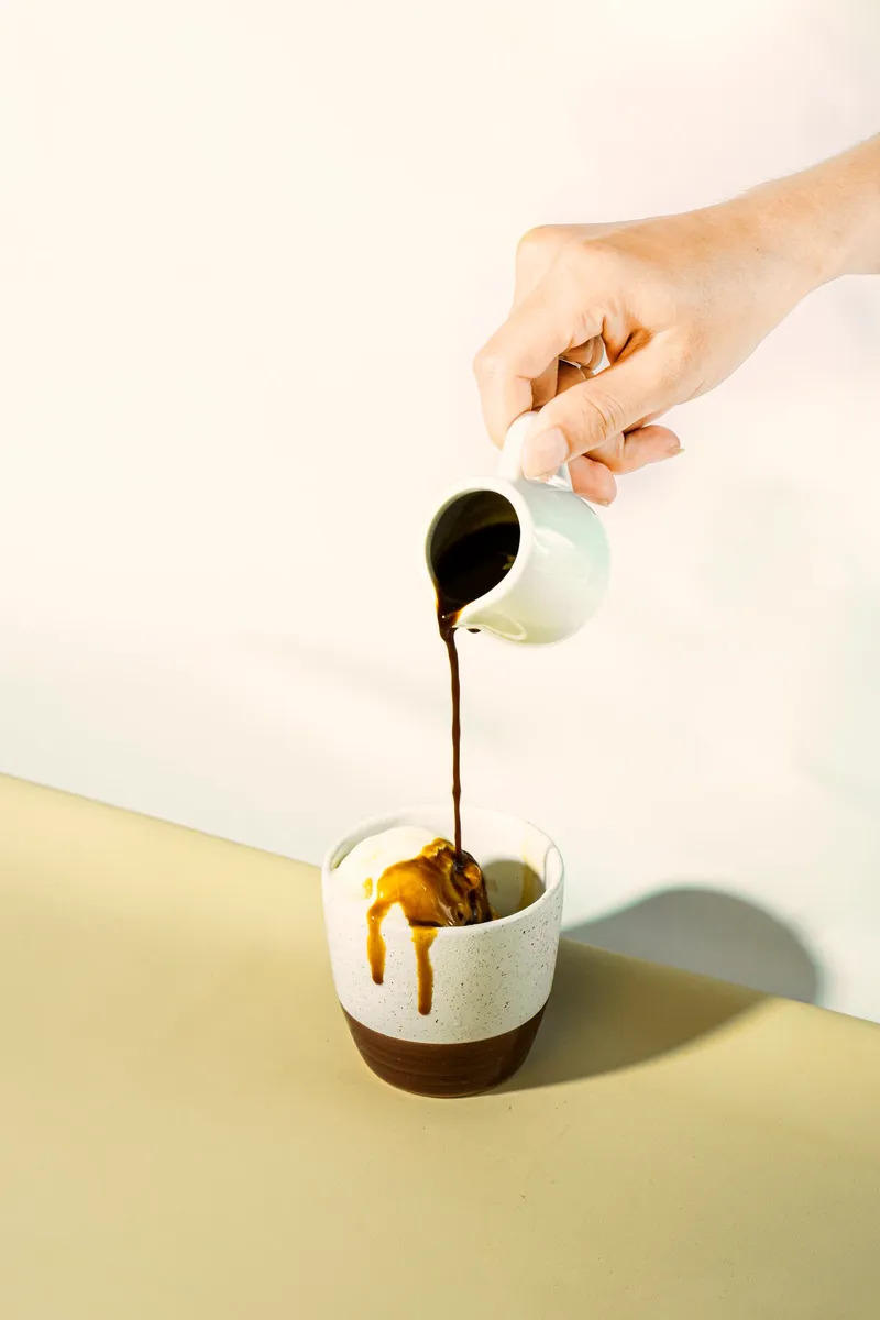 Espresso being poured over a scoop of vanilla ice cream