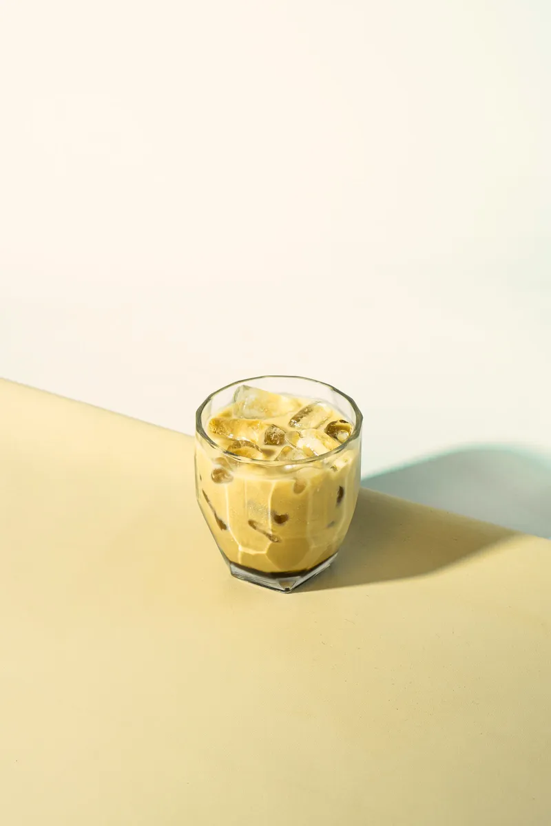 Flat white in a glass on a pale background