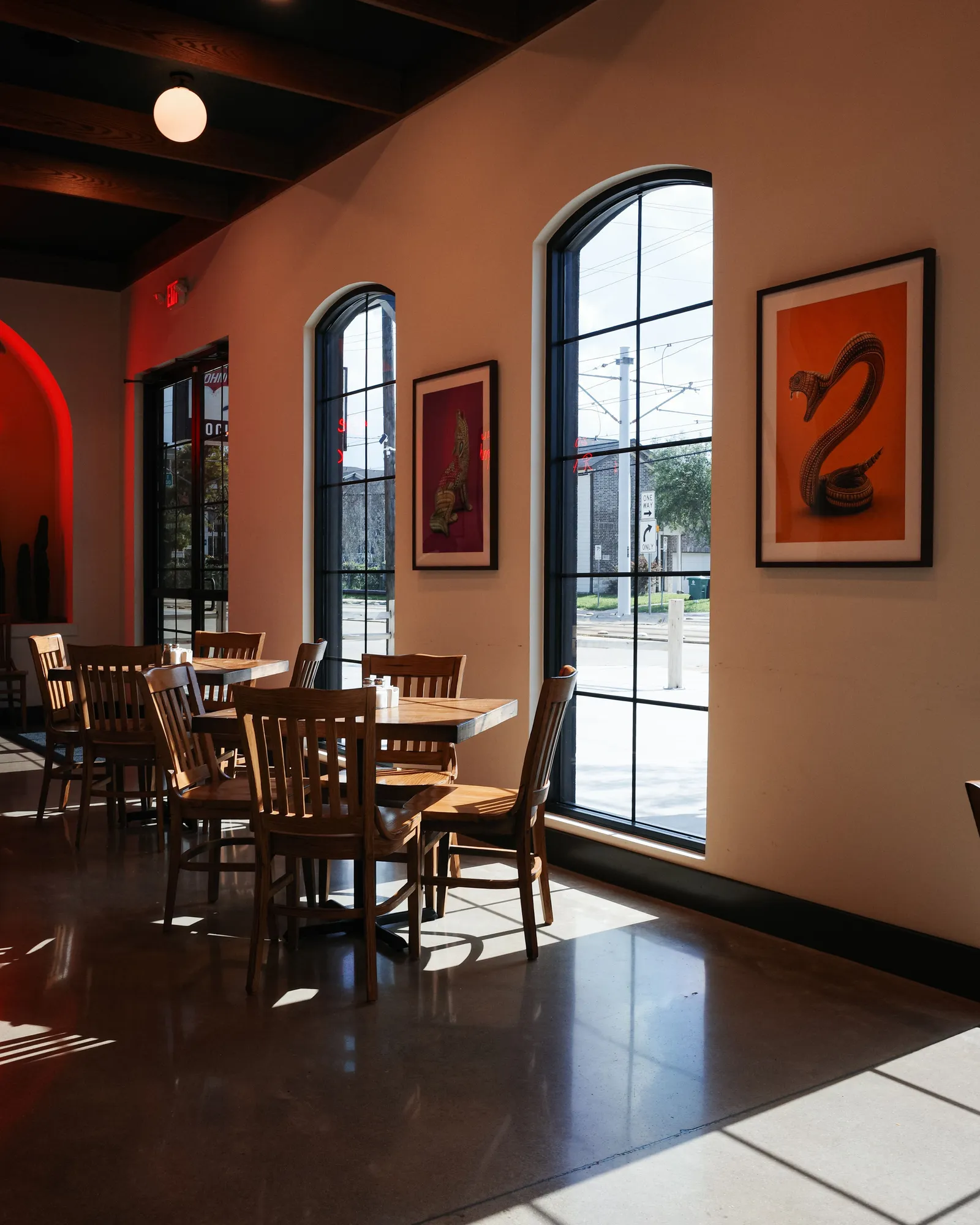 Café room with tall arched windows and sunlight pooling on a polished floor